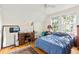 Bedroom has hardwood floors, and is lit by a window and lamp plus includes a desk and sewing machine at 348 7Th Ne St, Atlanta, GA 30308