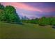 Scenic view of the city skyline from a nearby park, framed by lush trees and a vibrant sky at 348 7Th Ne St, Atlanta, GA 30308