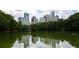 Scenic view of the city skyline reflected in a tranquil lake surrounded by lush greenery at 348 7Th Ne St, Atlanta, GA 30308
