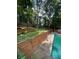 Tiered backyard landscaping beside a pool featuring decorative greenery and stone walkways for an inviting outdoor space at 4819 Coppedge Trl, Peachtree Corners, GA 30096