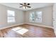 Sunlit bedroom featuring hardwood floors, a ceiling fan, and windows overlooking the surrounding neighborhood at 870 Gaston Sw St, Atlanta, GA 30310