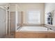 Main bathroom featuring a large soaking tub, glass shower, and tiled walls at 218 Ballymore Lane Ln, Acworth, GA 30102