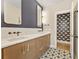 Modern bathroom featuring a double vanity, stylish mirrors, and unique floor tiles at 28 Peachtree Hills Ne Ave, Atlanta, GA 30305
