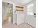 Bright entryway featuring hexagon tile flooring, a white cabinet and stylish wooden floating shelves at 28 Peachtree Hills Ne Ave, Atlanta, GA 30305