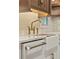 Close-up of sink with modern fixture, bright, clean subway tile and white farmhouse sink at 28 Peachtree Hills Ne Ave, Atlanta, GA 30305