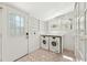 Charming laundry room featuring white cabinets, shelves, hexagon floors and modern appliances at 28 Peachtree Hills Ne Ave, Atlanta, GA 30305
