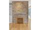 Cozy living room featuring a stone fireplace, built-in shelving, and hardwood floors at 28 Peachtree Hills Ne Ave, Atlanta, GA 30305