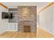 Cozy living room featuring a stone fireplace, built-in shelving, and hardwood floors at 28 Peachtree Hills Ne Ave, Atlanta, GA 30305