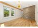 Sun-filled living room with hardwood floors, stone accent wall, and large windows at 28 Peachtree Hills Ne Ave, Atlanta, GA 30305