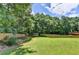 Spacious backyard area with trees and a wooden fence at 5385 Spotted Fawn Ct, Suwanee, GA 30024