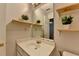 This light-filled bathroom has a single vanity and plants on floating shelves that add a nice touch at 5385 Spotted Fawn Ct, Suwanee, GA 30024