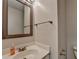 Neat bathroom with an oval sink and decorative framed mirror, providing a clean and functional space at 5385 Spotted Fawn Ct, Suwanee, GA 30024