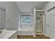 This bathroom features a soaking tub, glass shower, and large window that provides natural light at 5385 Spotted Fawn Ct, Suwanee, GA 30024