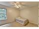 This cozy bedroom has a ceiling fan, carpet floors, and a large window for natural light at 5385 Spotted Fawn Ct, Suwanee, GA 30024