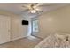 This cozy bedroom has a ceiling fan, carpet, and a large window that allows for plenty of light at 5385 Spotted Fawn Ct, Suwanee, GA 30024