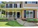 Inviting front porch with white railing, lush landscaping, and brick accents at 5385 Spotted Fawn Ct, Suwanee, GA 30024