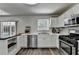 Bright kitchen boasting stainless steel appliances, white cabinets, and natural light, creating an inviting cooking space at 5385 Spotted Fawn Ct, Suwanee, GA 30024