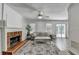 Inviting living room featuring a brick fireplace, ceiling fan, neutral colors, and sliding glass doors to the exterior at 5385 Spotted Fawn Ct, Suwanee, GA 30024