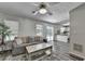 Comfortable living room with ceiling fan, gray sofa, and access to the kitchen, offering a seamless flow at 5385 Spotted Fawn Ct, Suwanee, GA 30024