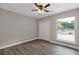 Bright bedroom with hardwood floors, ceiling fan, closet, and view of trees at 1272 Sherwood Dr, Norcross, GA 30093