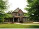 Stunning two-story home featuring a stone and brick facade, complemented by a lush green lawn and mature trees at 2845 Echols Road Rd, Cumming, GA 30041