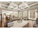 Open living room with coffered ceilings, hardwood floors, fireplace, and comfortable furniture at 2845 Echols Road Rd, Cumming, GA 30041