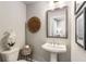 Charming half bathroom featuring a pedestal sink, a round decor piece, a lovely flower, and framed art at 4358 Parkside Pl, Atlanta, GA 30342