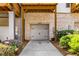 Exterior shot of the garage door with white brick, lush greenery, and visible house numbers above the entrance at 4358 Parkside Pl, Atlanta, GA 30342