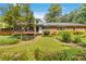 View of the home and deck from the backyard with landscaping at 2628 Tanglewood Rd, Decatur, GA 30033