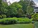 Lush backyard featuring mature trees, green lawn, and a deck with a grill, creating a private outdoor oasis at 2628 Tanglewood Rd, Decatur, GA 30033