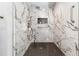 Luxurious shower featuring elegant marble walls, a sleek shower head and contemporary hexagon-shaped flooring at 2628 Tanglewood Rd, Decatur, GA 30033