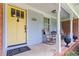 Inviting front porch features a yellow door, seating, and charming decorative details at 2628 Tanglewood Rd, Decatur, GA 30033