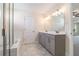 Bathroom with double sink vanity, tile floor, and tub-shower combo with glass door at 129 Academy Ln, Canton, GA 30114