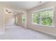 Bright living room featuring neutral walls, plush carpet, and sunlit windows with wooded views at 129 Academy Ln, Canton, GA 30114