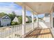 Covered front porch with wood deck and white columns, offering neighborhood views at 129 Academy Ln, Canton, GA 30114