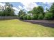 Spacious, fenced backyard with a grassy area and a landscaped flower bed at 207 Cross Rd, Acworth, GA 30102