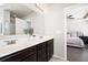 Bright bathroom boasts a double vanity with dark cabinets and a view into the serene main bedroom at 207 Cross Rd, Acworth, GA 30102