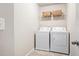 Functional laundry area with washer, dryer, and shelving for storage at 207 Cross Rd, Acworth, GA 30102