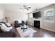 Cozy living room featuring a fireplace, ceiling fan, and ample natural light from two windows at 207 Cross Rd, Acworth, GA 30102