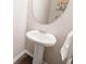 Elegant powder room with a pedestal sink, round mirror, and decorative accents at 207 Cross Rd, Acworth, GA 30102