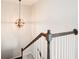Staircase with wooden banister, white spindles, and an elegant chandelier, creating a warm and inviting atmosphere at 207 Cross Rd, Acworth, GA 30102