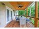 Comfortable back porch features a ceiling fan, outdoor table, and chairs at 332 Mount Zion Rd, Oxford, GA 30054