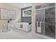 Bathroom featuring a soaking tub with a separate glass enclosed shower and marble flooring at 332 Mount Zion Rd, Oxford, GA 30054