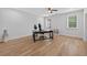 A large, naturally lit room with wood floors, a desk, a ceiling fan, and white walls at 332 Mount Zion Rd, Oxford, GA 30054