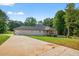 Tan home with a long concrete driveway on a lush green lawn and a wooden deck at 332 Mount Zion Rd, Oxford, GA 30054