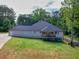 Tan home with a long concrete driveway on a lush green lawn and a wooden deck at 332 Mount Zion Rd, Oxford, GA 30054