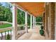 Spacious covered front porch with elegant railings, perfect for enjoying the serene, wooded surroundings at 332 Mount Zion Rd, Oxford, GA 30054