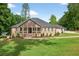 Lovely one-story home featuring a covered front porch, complemented by a lush, green lawn and mature trees at 332 Mount Zion Rd, Oxford, GA 30054