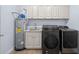 Modern laundry room featuring gray cabinets, granite countertops, sink, and washer/dryer at 332 Mount Zion Rd, Oxford, GA 30054