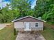Charming outbuilding with horizontal siding and a stone foundation on a lush green lawn at 332 Mount Zion Rd, Oxford, GA 30054